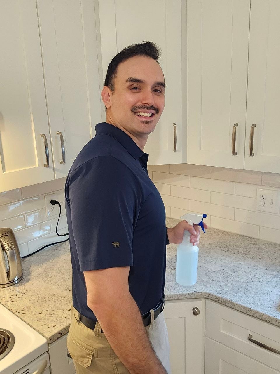 Brian, owner of Bayberry Cleaning, smiling while cleaning a kitchen
